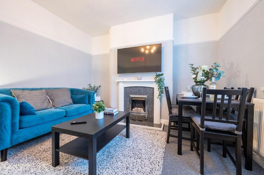 uma sala de estar com um sofá azul e uma mesa em Dos Road by Tŷ SA em Newport