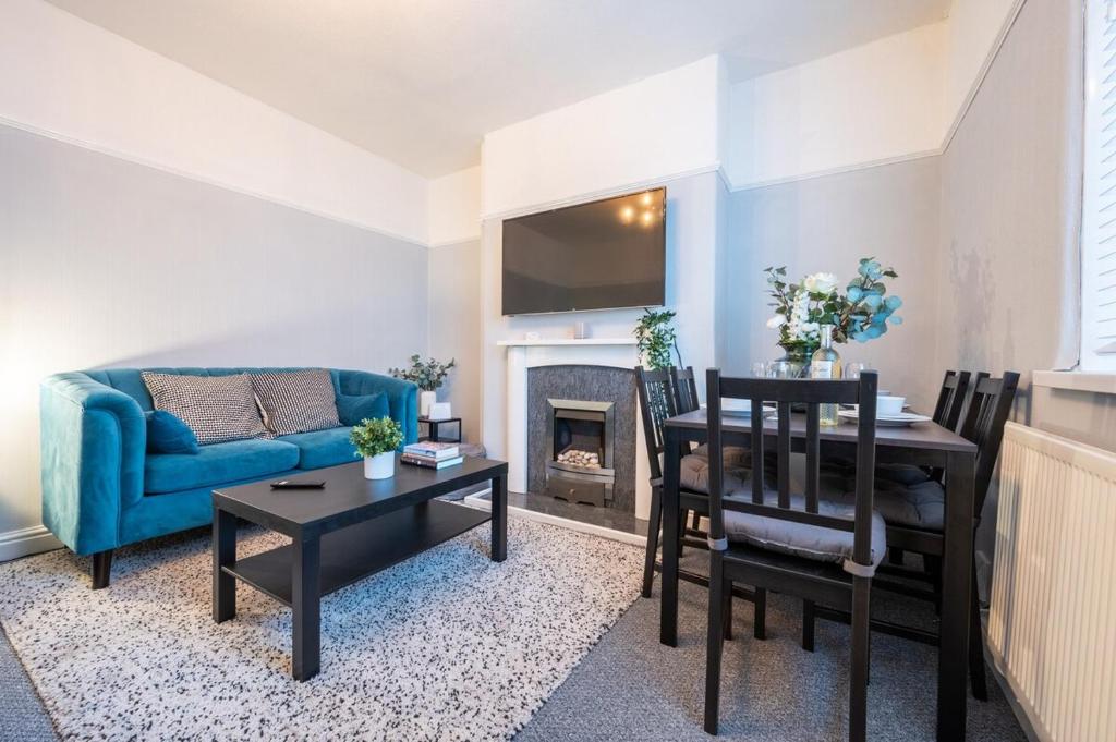 紐波特的住宿－Dos Road by Tŷ SA，一间带蓝色沙发的客厅和一间用餐室