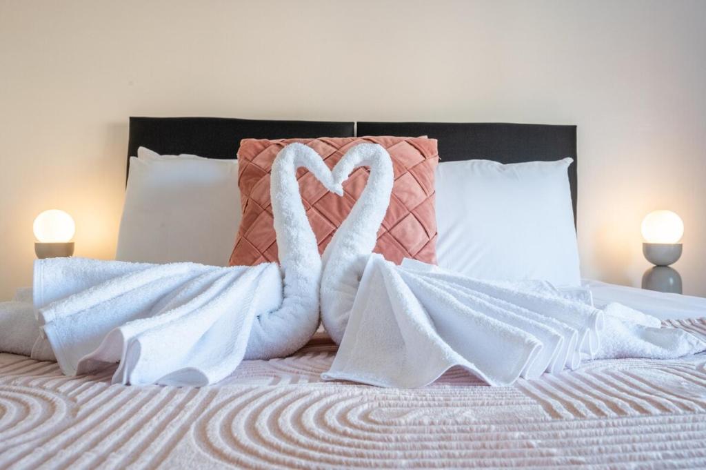 two swans made out of towels on a bed at Rogerstone House by Tŷ SA in Rogerstone