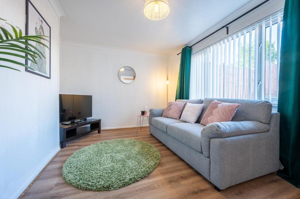 a living room with a couch and a large window at Rogerstone House by Tŷ SA in Rogerstone