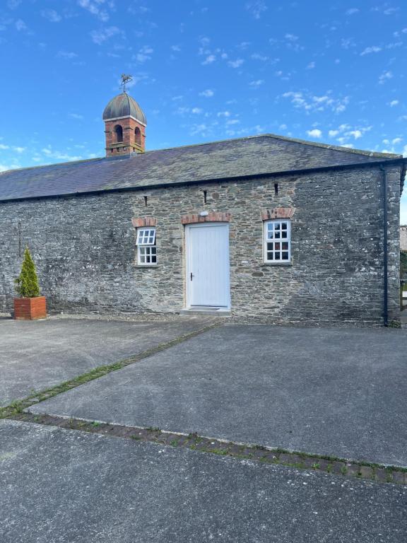 ein altes Steingebäude mit einer weißen Tür in der Unterkunft Rokeby cottage in Drogheda