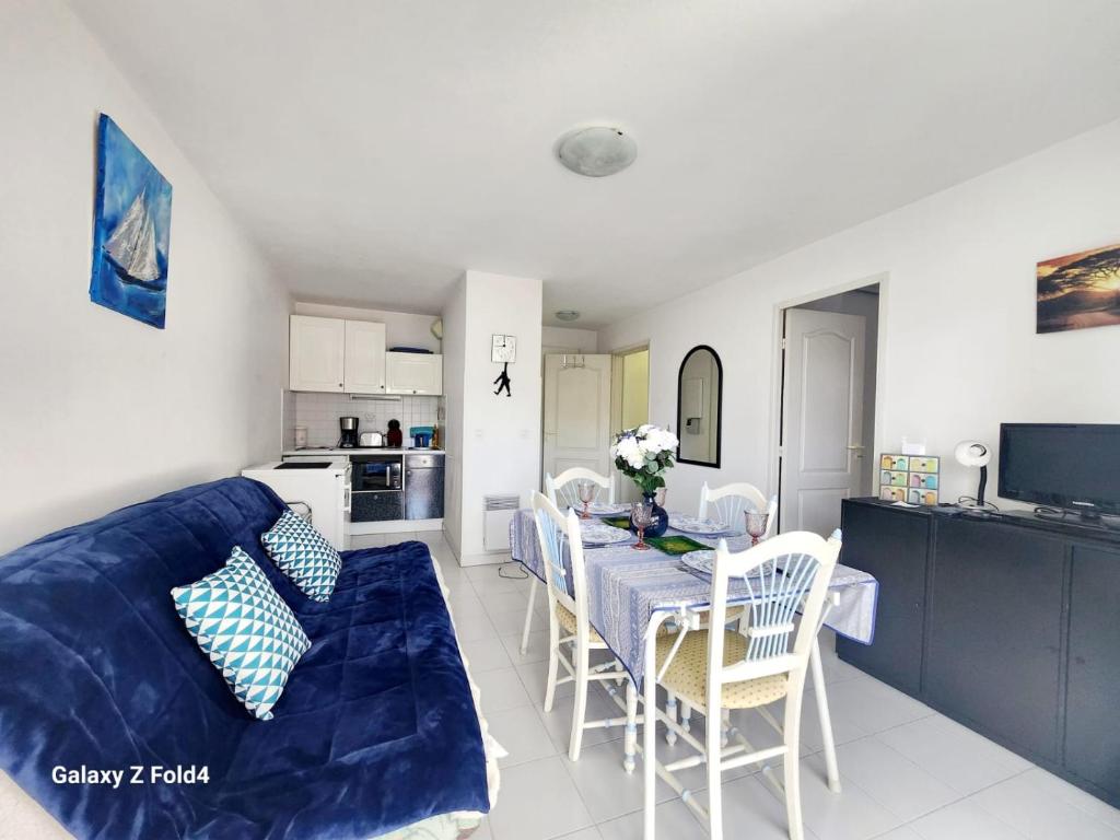 un salon avec une table et un canapé bleu dans l'établissement Quercus YourHostHelper, à Saint-Raphaël