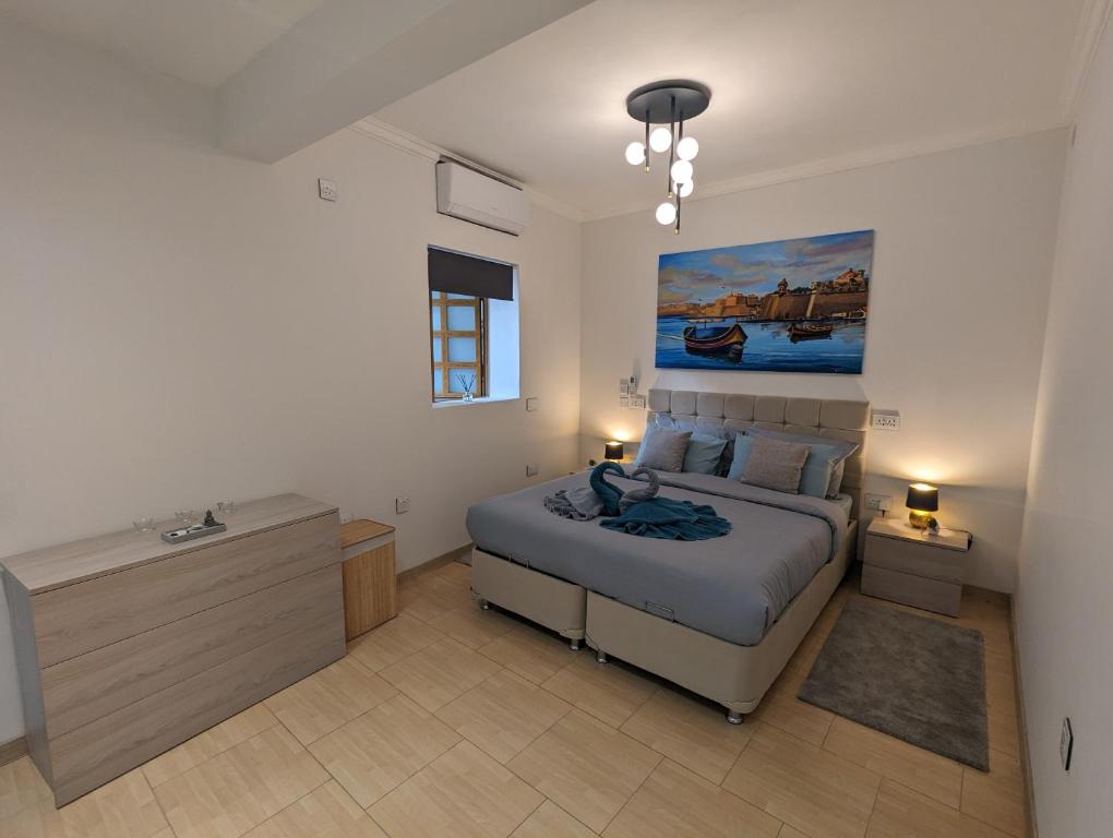 a bedroom with a bed and a painting on the wall at Modern & Cosy 1 Bed Maisonette - Close to Salina Bay in St. Paul's Bay