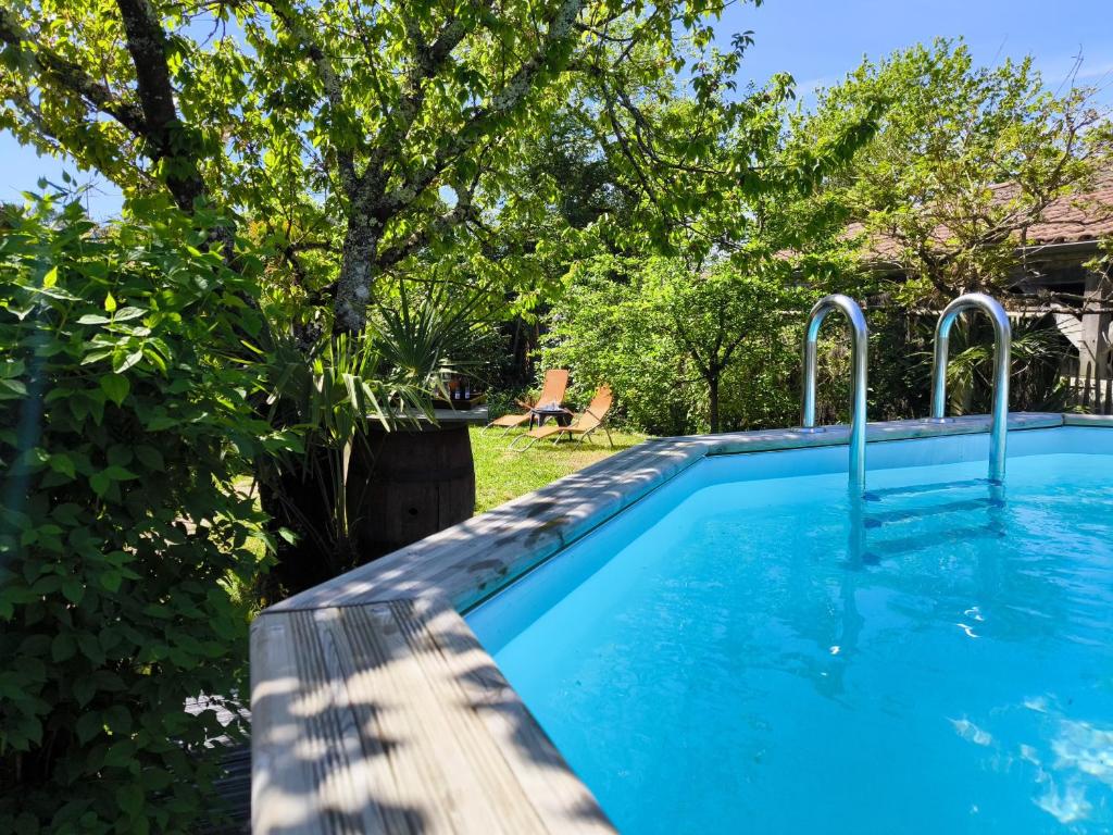 una piscina en un patio con árboles en Detente et parenthese familiale a Ares, en Arès