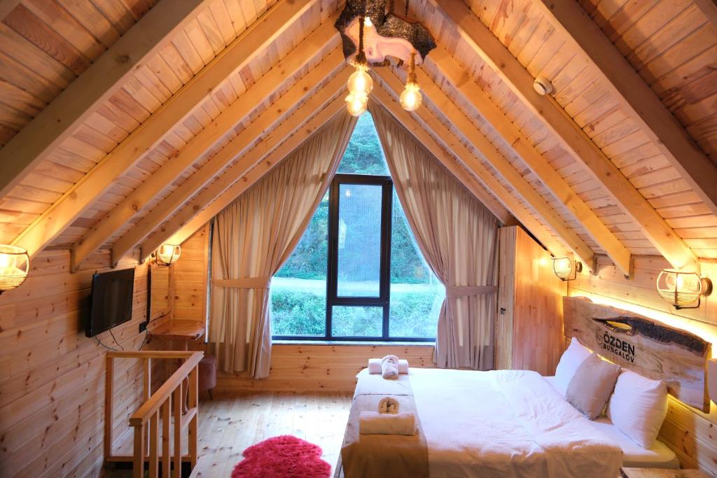 um quarto com uma cama grande numa casa de madeira em Özden Bungalow em Çamlıhemşin