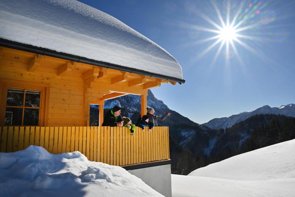 a group of people standing on the balcony of a building at Cottage Osojnik - Alpine escape with Wellness in Solčava