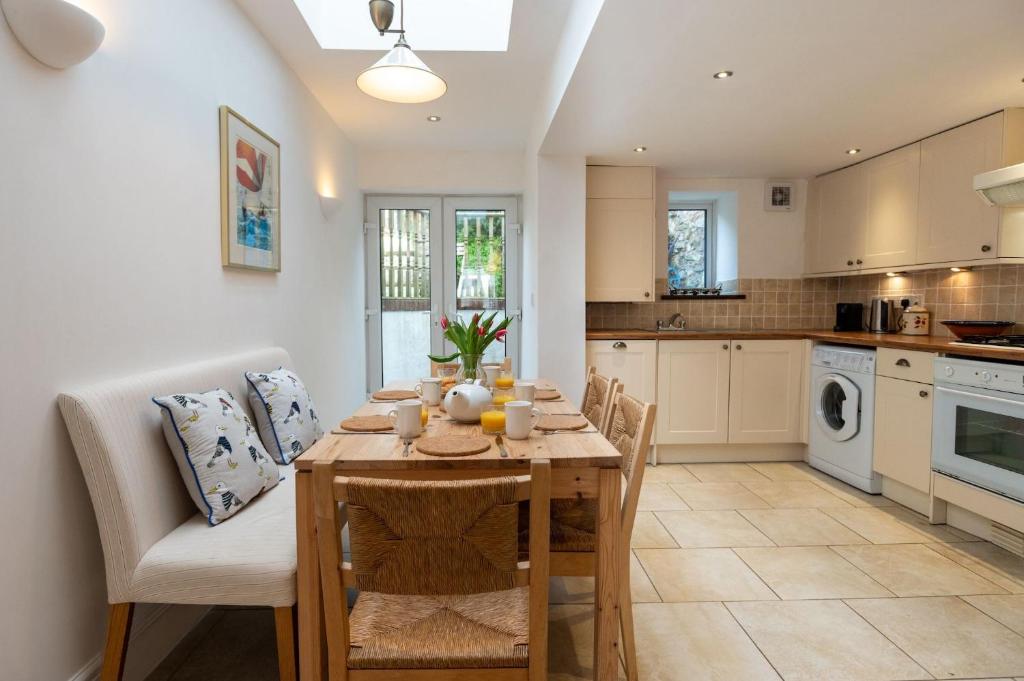 a kitchen and dining room with a table and chairs at 24 Rosemary Lane in Beaumaris
