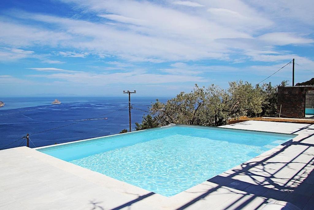 a blue swimming pool with a view of the ocean at Hillside Villa over Lemonodasos in Galatas