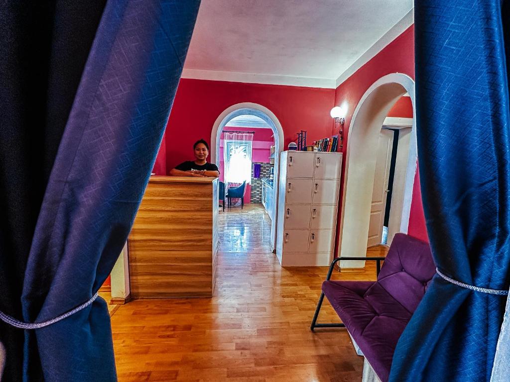 a man sitting at a counter in a room at Red Apple Hostel in Almaty