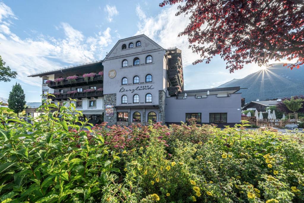 ゼーフェルト・イン・チロルにあるHotel Bergland All Inclusive Top Qualityの目の前に花がたくさん咲く建物