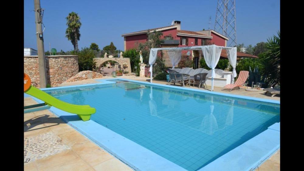 een zwembad met een glijbaan voor een huis bij La traversa in Sannicola