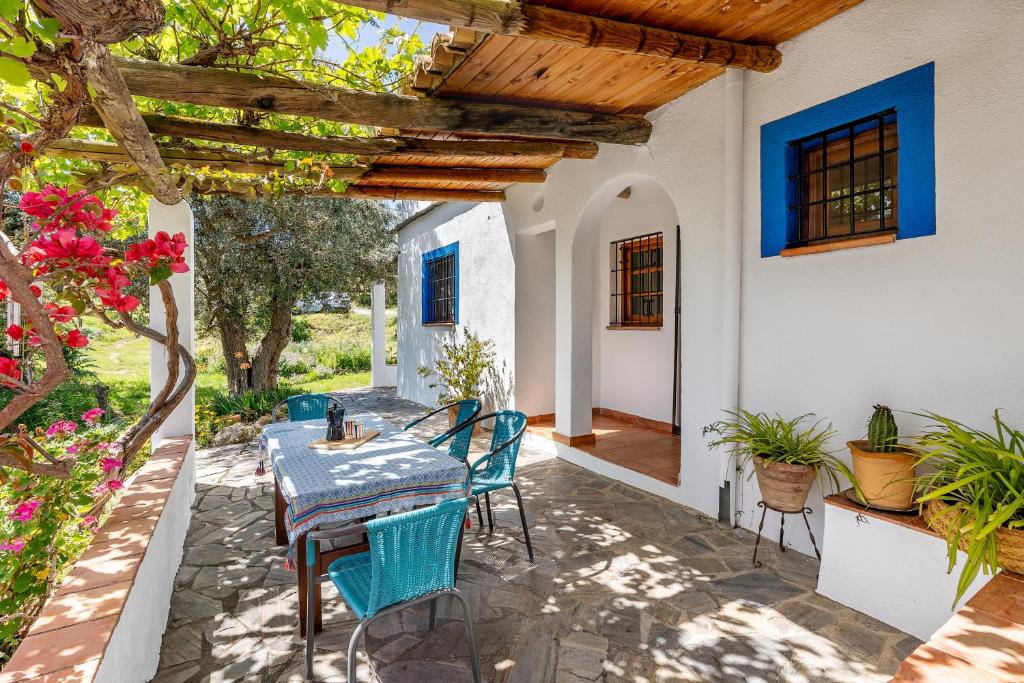patio con tavolo e sedie sotto un pergolato di Casita de la Huerta a Granada