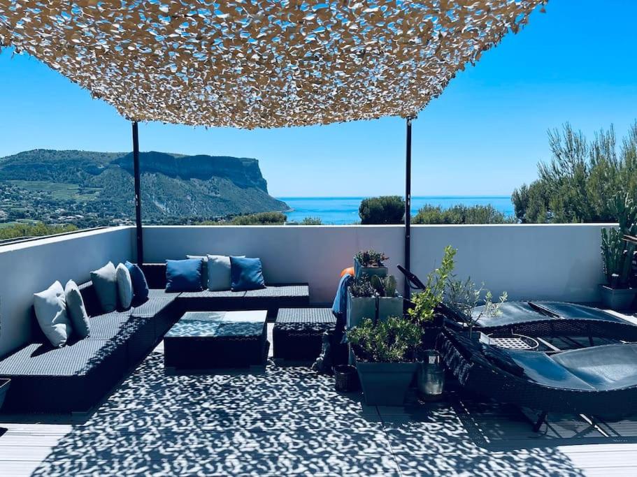 une terrasse avec un canapé et un bain à remous dans l'établissement APPARTEMENT VUE SPLENDIDE CASSIS-CLASSE 3 ETOILES, à Cassis