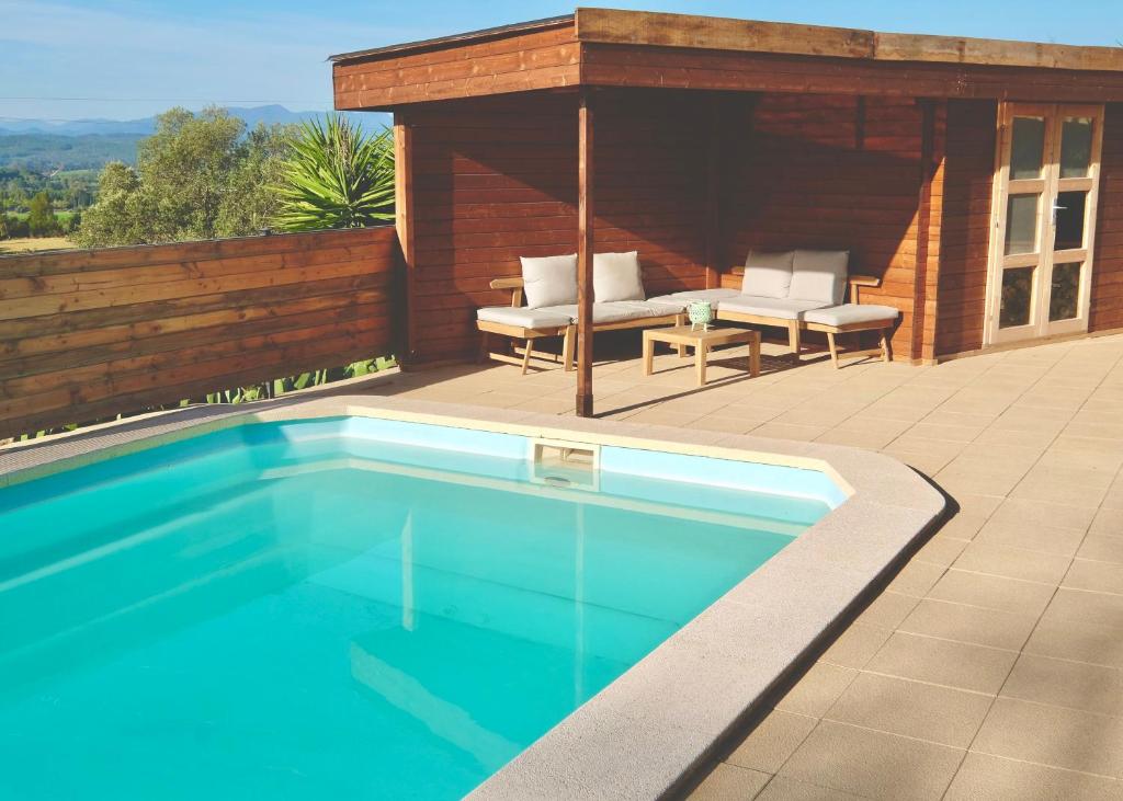 a swimming pool in front of a house with a pavilion at Torre Costa Brava in Garrigás