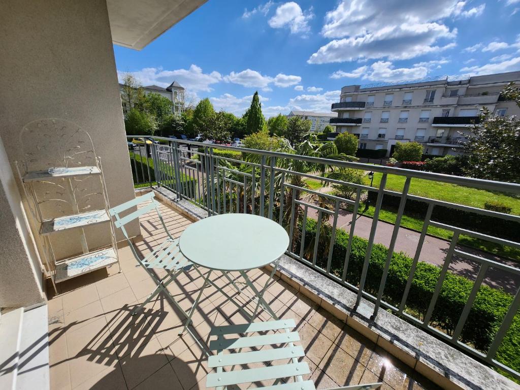 a balcony with a white table and chairs at 5' Disneyland cozy appartment in Montévrain