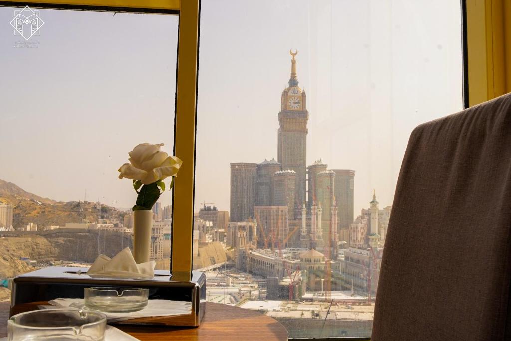 a table with a window with a view of a city at Manarat Gaza Hotel - Al Haram Tower in Mecca