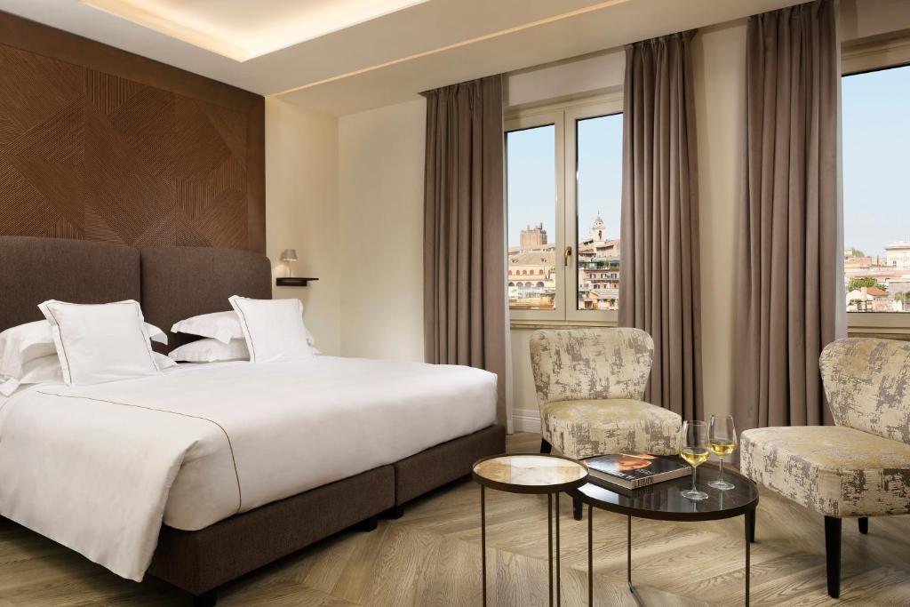 FH55 Grand Hotel Palatino في روما: غرفة فندقية بسرير وطاولة وكراسي