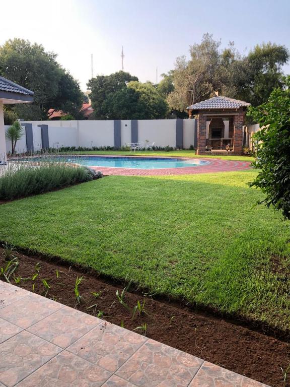 a yard with a swimming pool and a house at Serene Guesthouse in Middelburg