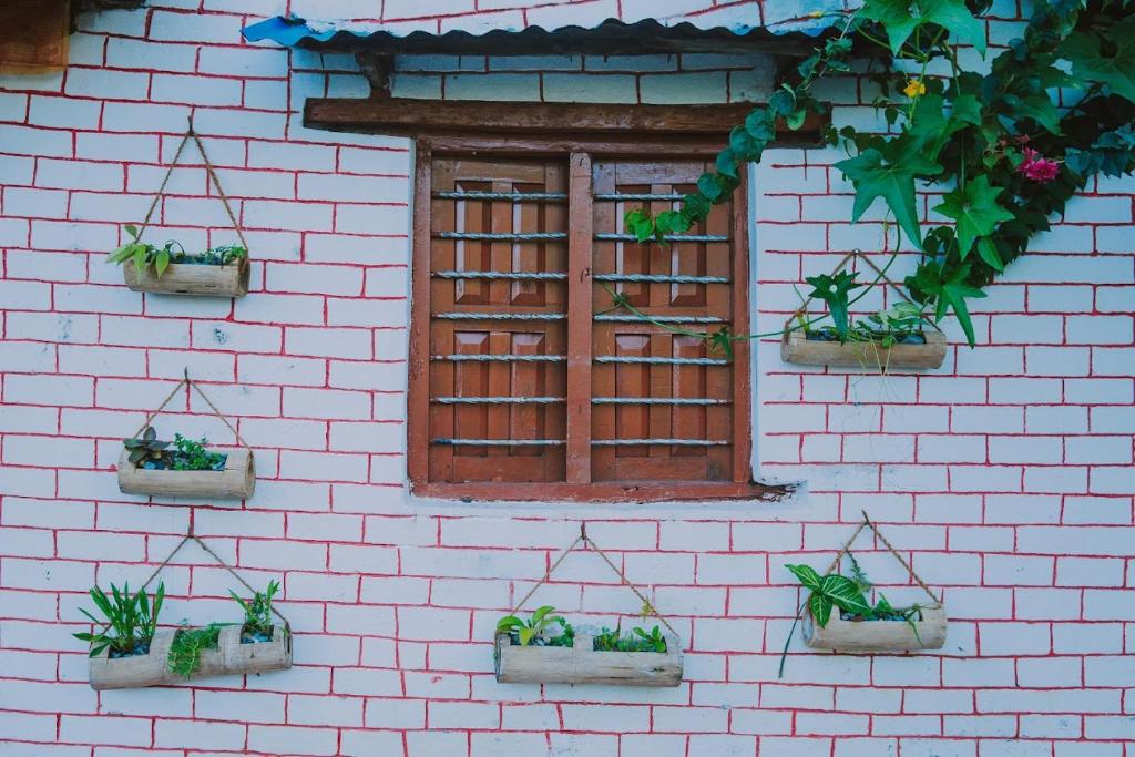 uma parede de tijolos com quatro vasos de plantas em NAMA STAY HOME em Pokhara