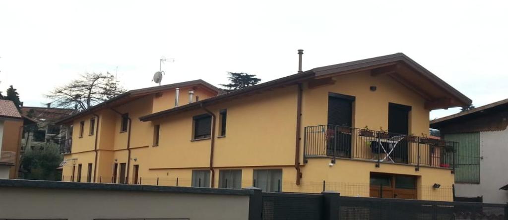 a yellow building with a balcony on the side of it at casa di Ale e Bea in Dervio