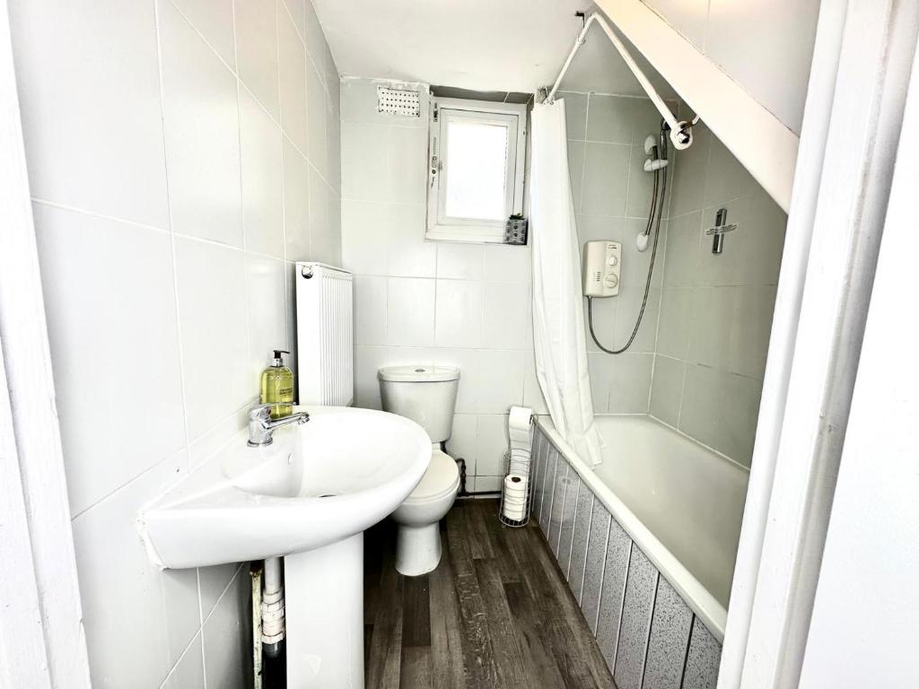 y baño con lavabo, aseo y ducha. en Serviced 4 bed 2 bath Manor Park House, en Londres