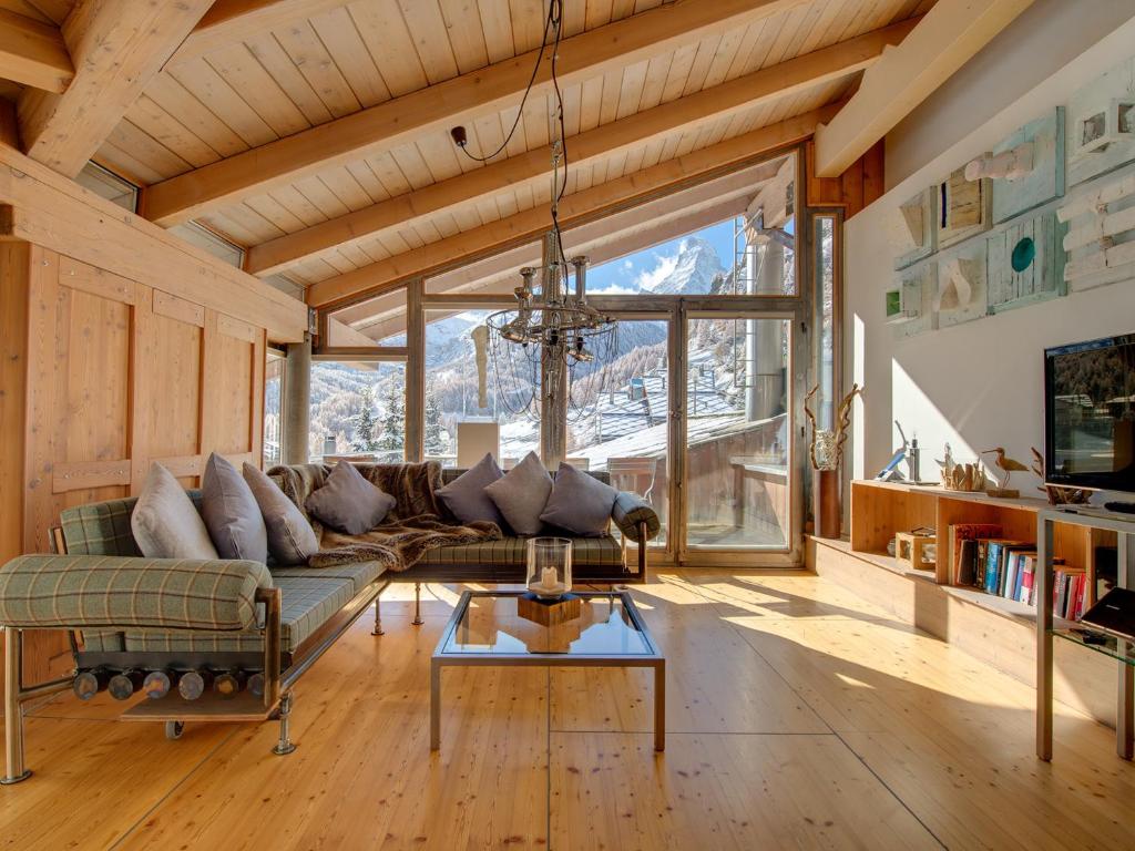 a living room with a couch and a table at Backstage Hotel Serviced Apartments in Zermatt