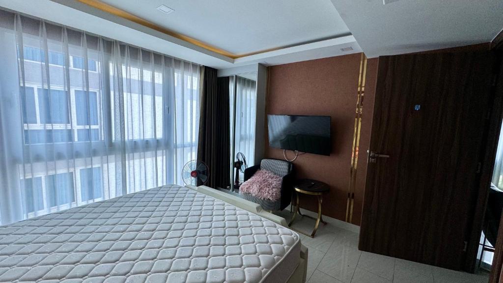 - une chambre avec un lit et une grande fenêtre dans l'établissement Elegant 2BR Condo Grand Avenue Pattaya, à Pattaya