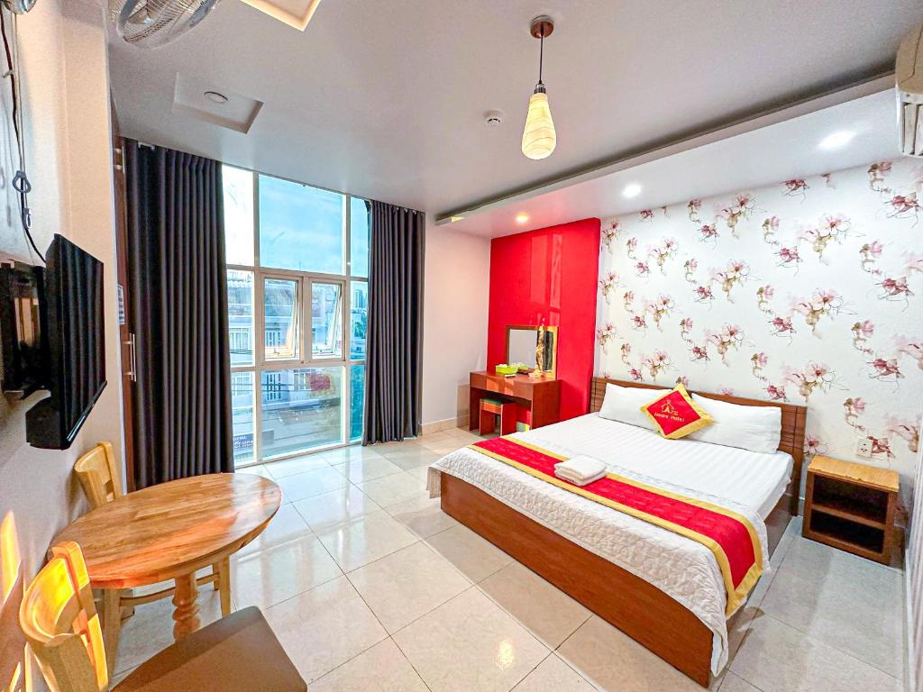 Un dormitorio con una cama, una mesa y un escritorio. en Amura Hotel Quận 7, en Ho Chi Minh