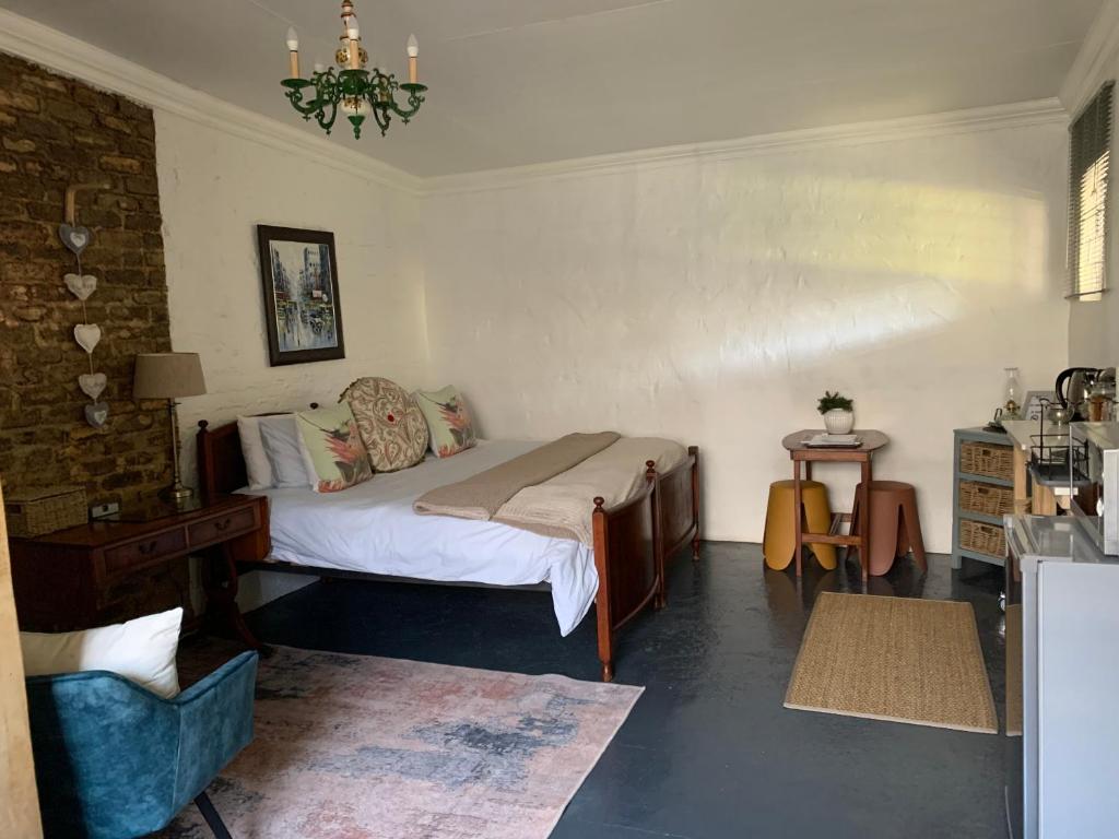 um quarto com uma cama e uma cadeira em 117 on Oak em Cullinan