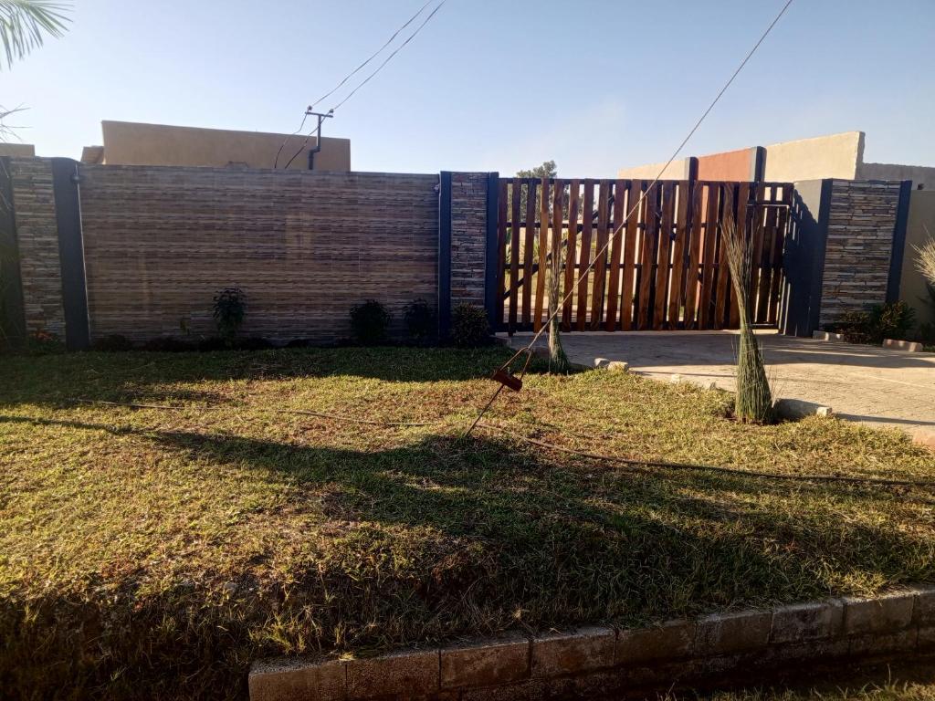 un patio con una valla delante de un edificio en Orchard Mist Lodges and Events en Kabwe