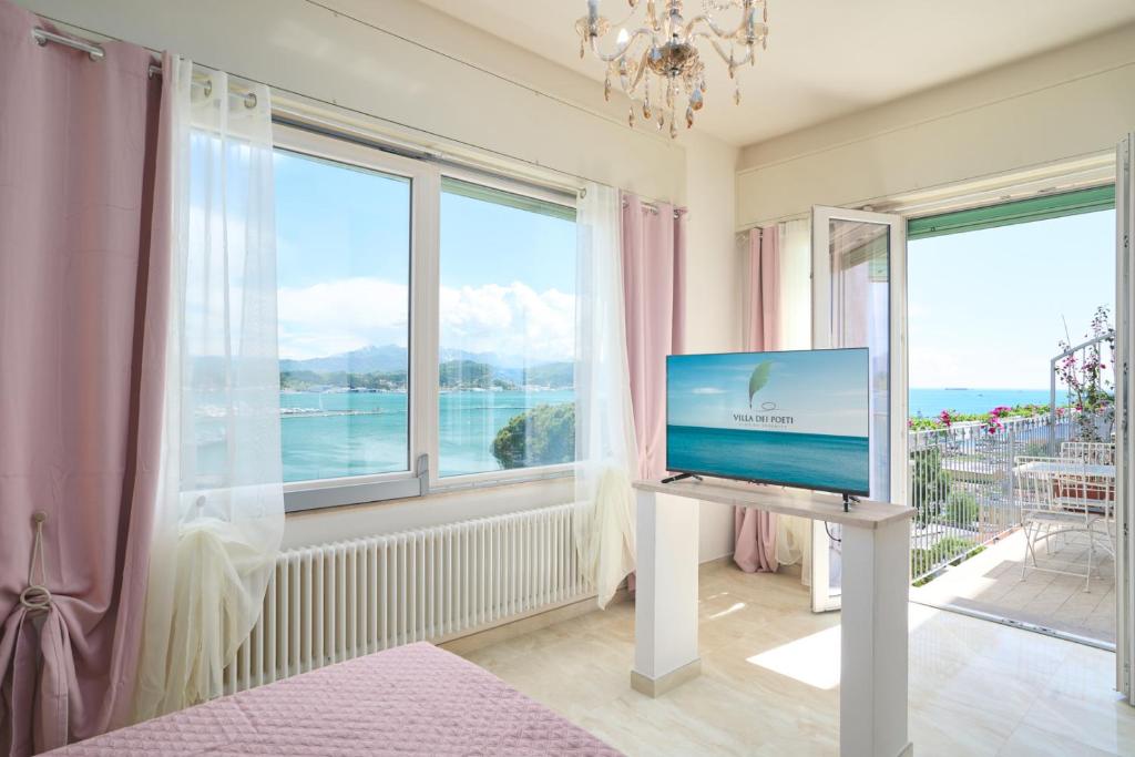 Zimmer mit einem TV auf einem Stand vor einem Fenster in der Unterkunft Villa dei Poeti in La Spezia