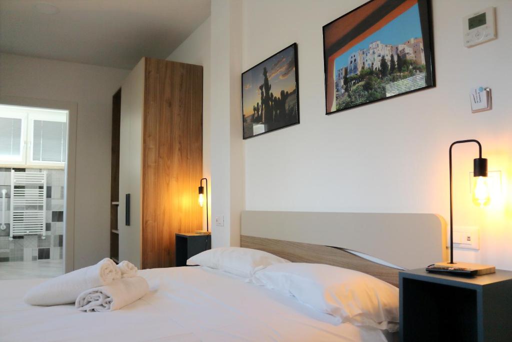 1 dormitorio con 1 cama blanca y 2 cuadros en la pared en Sperlonga Center Holiday en Sperlonga