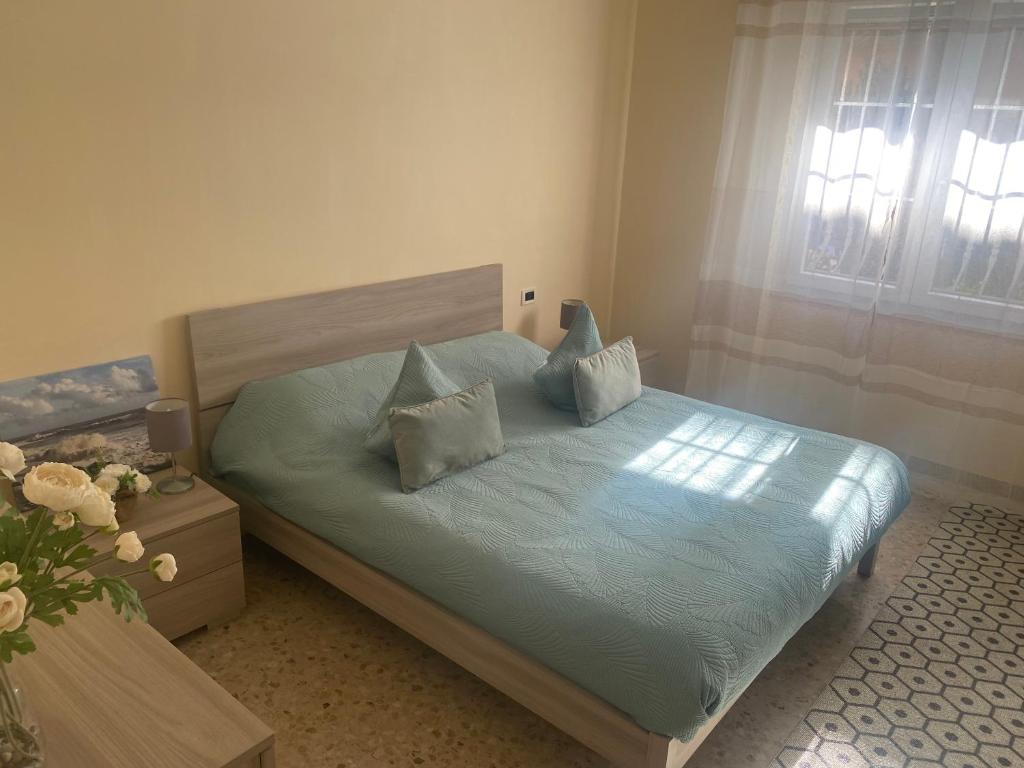a bedroom with a bed with blue sheets and pillows at New apartment next to the sea in Bordighera