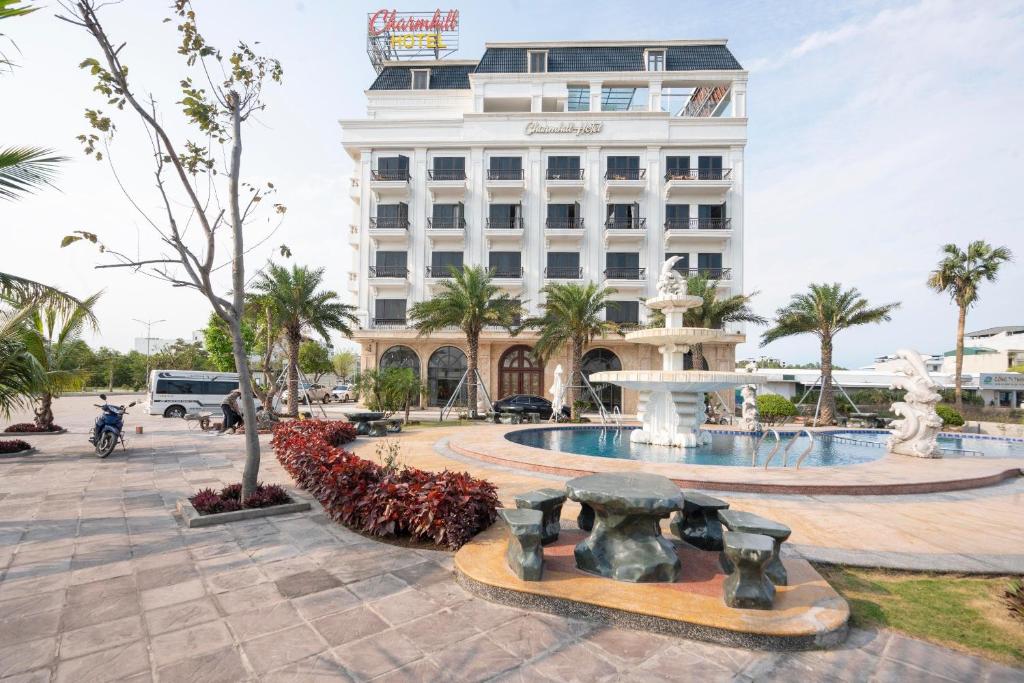 a hotel with a fountain in front of a building at Charmhill Hotel - Tuần Châu in Ha Long