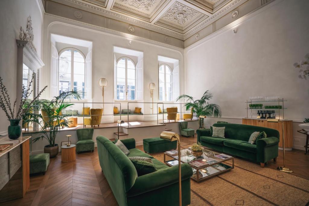 ein großes Wohnzimmer mit grünen Möbeln und Fenstern in der Unterkunft Casa G. Firenze in Florenz
