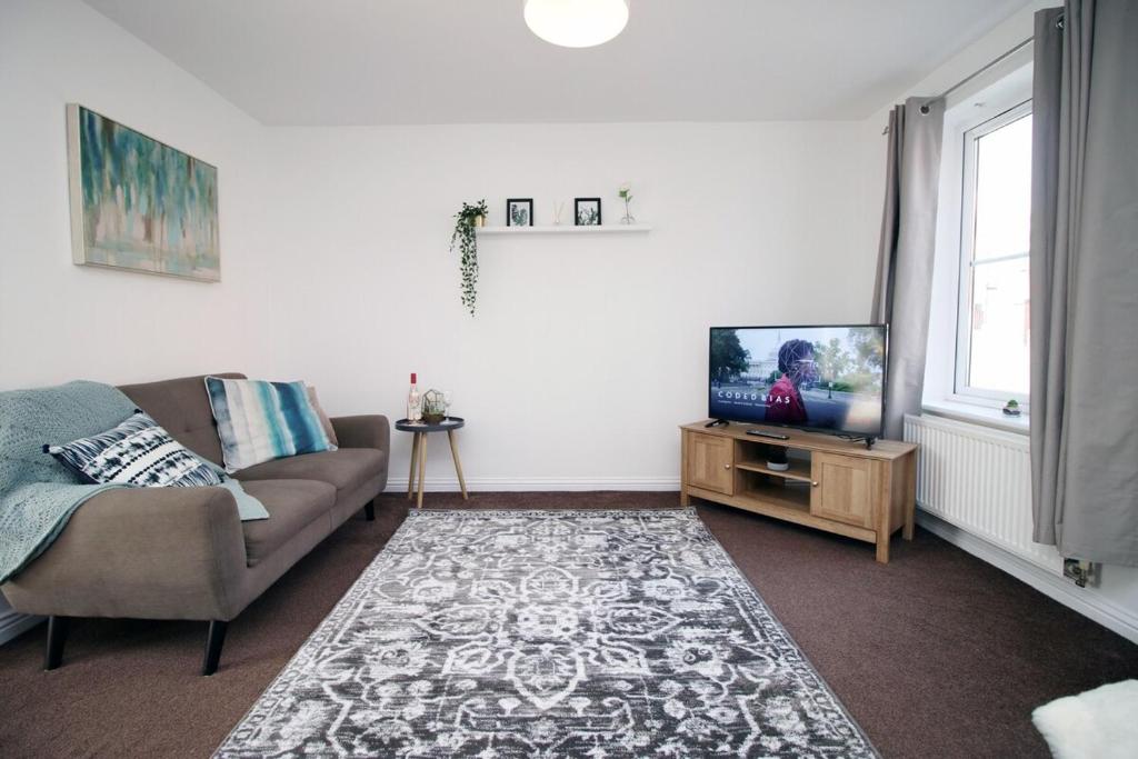 a living room with a couch and a television at Gwent View by Tŷ SA in Newport