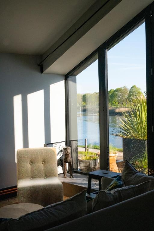 un salon avec un canapé et une grande fenêtre dans l'établissement Loft L'Écluse 1, parking gratuit, à Saint-Valery-sur-Somme