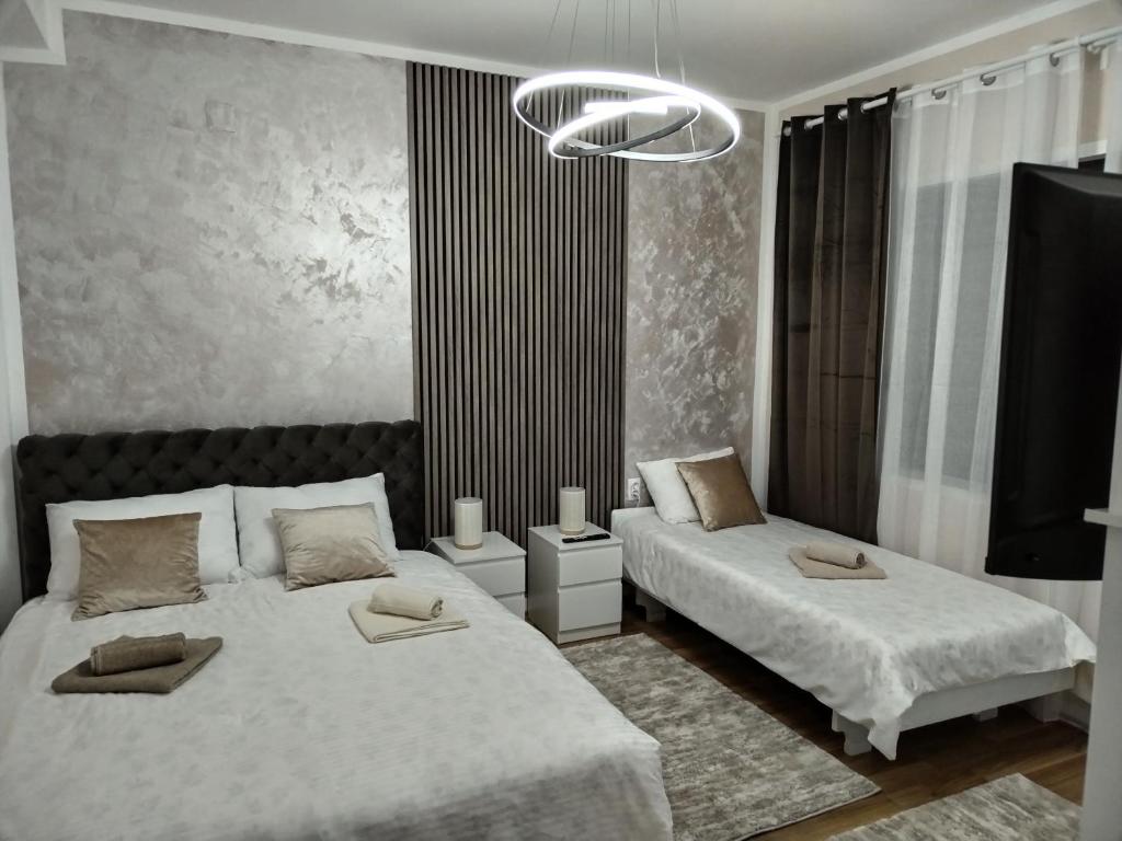 1 Schlafzimmer mit 2 Betten und einem Kronleuchter in der Unterkunft Apartman Tina in Sokobanja