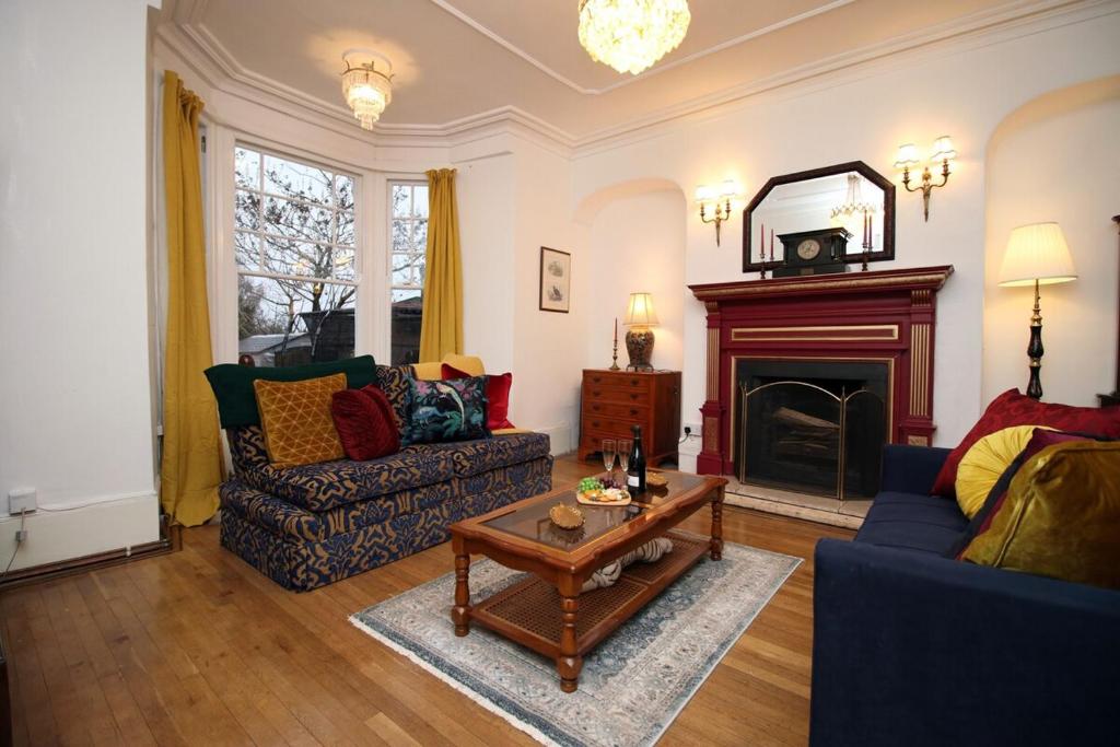 ein Wohnzimmer mit einem Sofa und einem Kamin in der Unterkunft Flora Suites by Tŷ SA in Newport