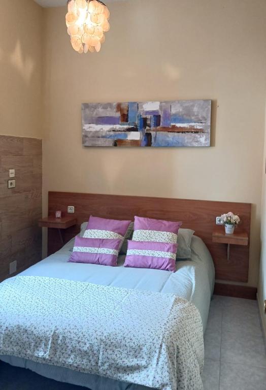 - une chambre avec un lit et des oreillers violets dans l'établissement Parada do Camiño de Santiago, à Betanzos