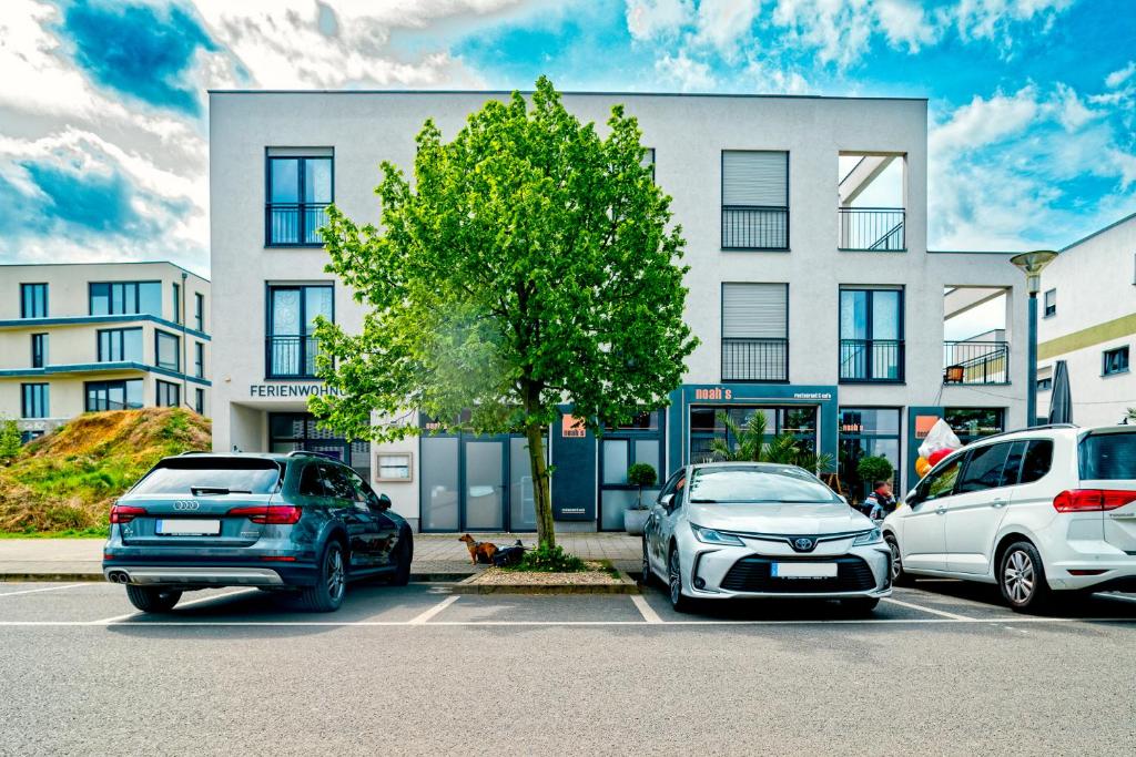twee auto's geparkeerd op een parkeerplaats voor een gebouw bij Appartements am Hafen in Zwenkau