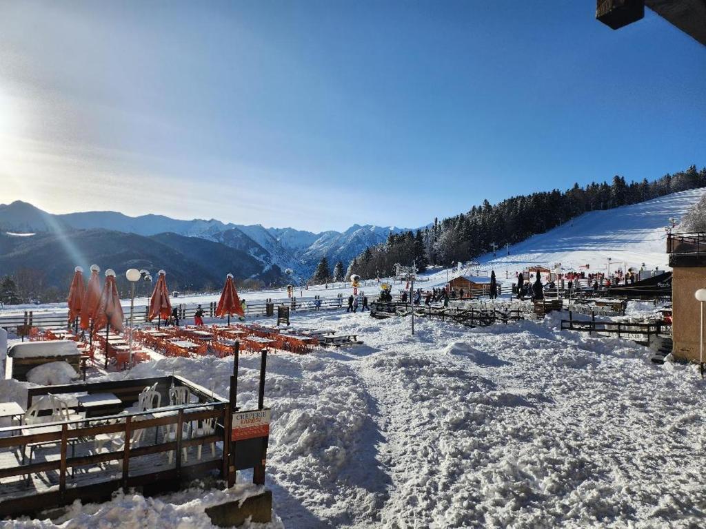 une piste enneigée avec tables et parasols dans l'établissement Les Isards Pied des pistes, à Ax-les-Thermes