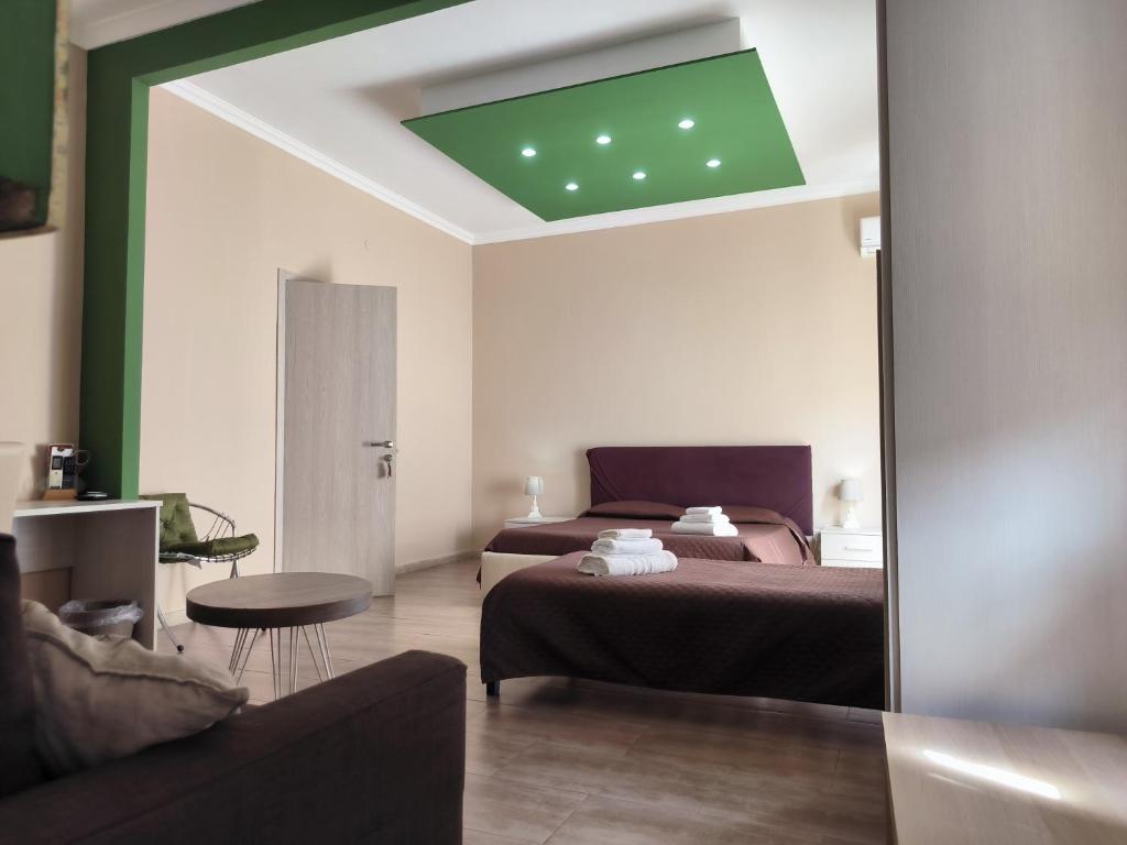 1 dormitorio con cama, sofá y espejo en Prestige B&B, en Catania