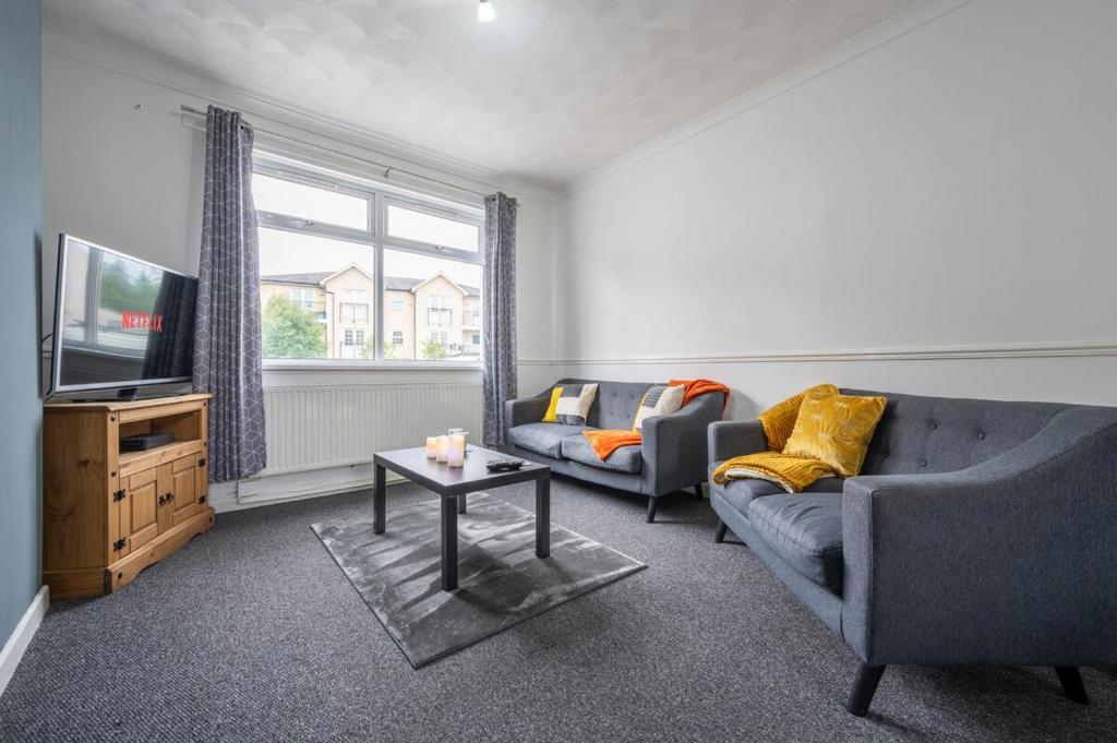 a living room with a couch and a tv at Maindee Parade by Tŷ SA in Newport