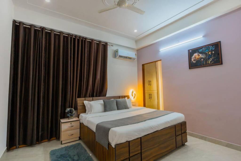 a bedroom with a large bed and a window at Skyport skies netflix prime rooftop in Jaipur
