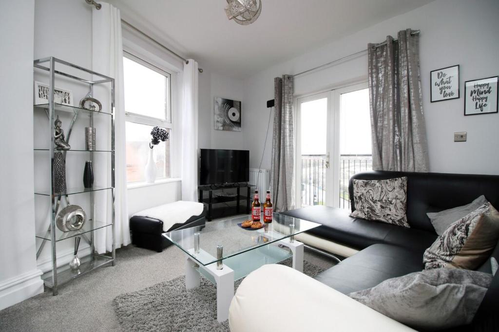 uma sala de estar com um sofá e uma mesa de vidro em Stunning sea views - Barry's Retreat by Tŷ SA em Barry