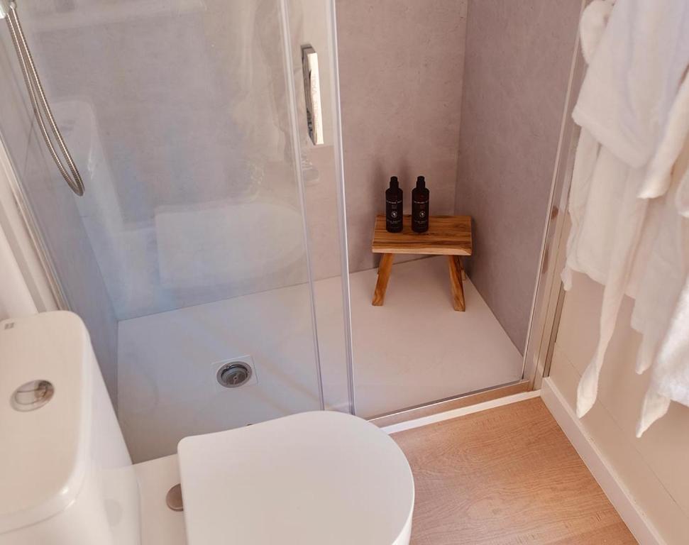 uma casa de banho branca com um chuveiro e um WC. em Camping Pla de la Torre em Sant Antoni de Calonge