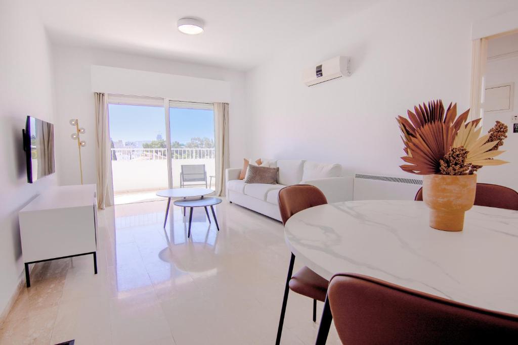sala de estar blanca con mesa y sofá en Phaedrus Living Modern City View Flat Nafi en Limassol