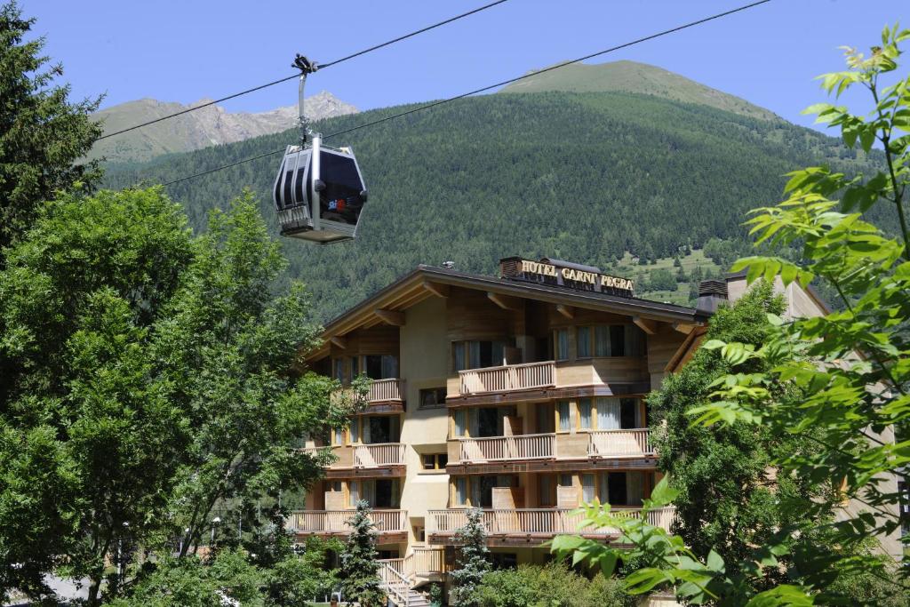 a gondola ride over a hotel in the mountains at Hotel Garni Pegrà in Ponte di Legno