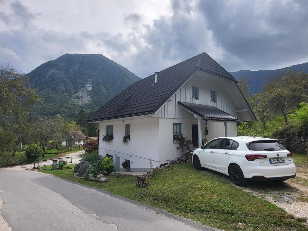 a white car parked in front of a house at Apartment Luka at Soča & Koritnica confluence in Bovec